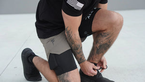 Person tying their shoes on a light gray floor