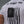 Person wearing a white t-shirt with a black graphic and text on the back against a gray background