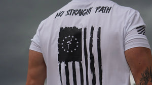 Person wearing a white t-shirt with a black graphic and text on the back against a gray background