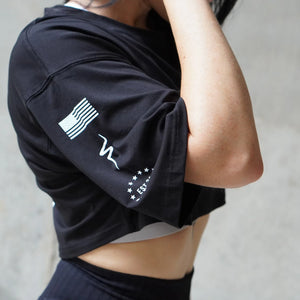 Person wearing a black athletic outfit with white graphics on a neutral background