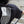 Person wearing a black t-shirt with a white flag design on the back, standing on steps.
