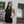 Woman in black athletic wear standing outdoors near a building