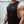 Person wearing a black tank top with a No Straight Path® logo, standing against a light-colored wall.