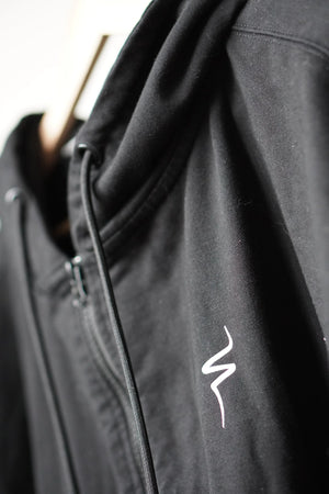 Black jacket with a white No Straight Path® logo on a blurred background