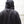 Person wearing a black hoodie with a plain background