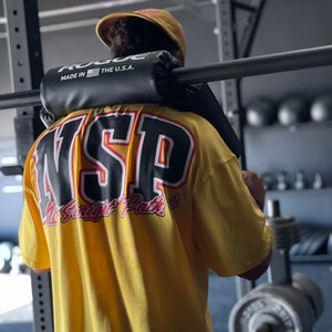 Person wearing a yellow 'NSP' shirt in a gym setting