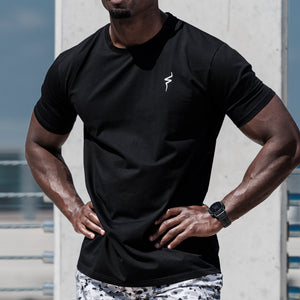 Man in athletic wear standing outdoors with a clear sky background